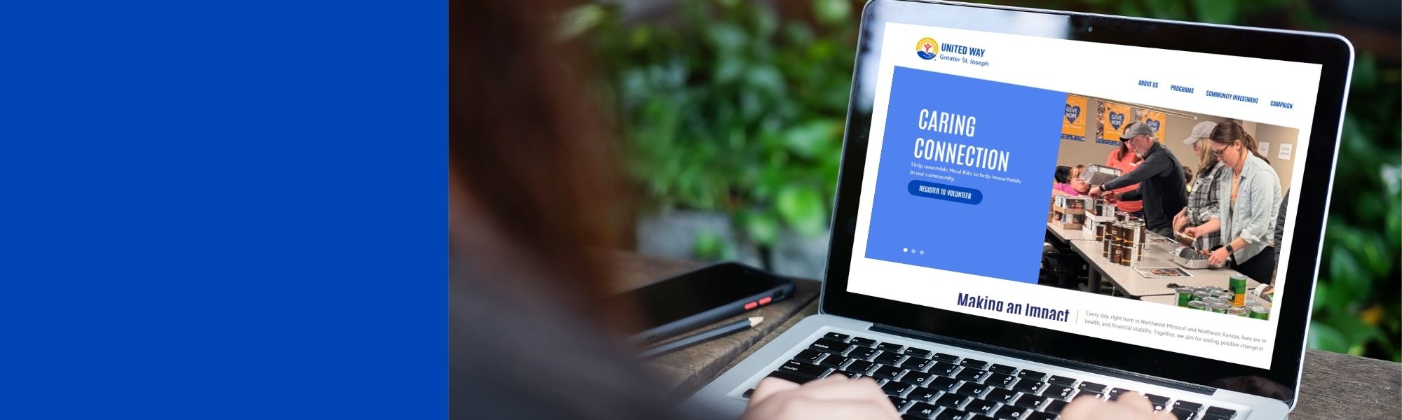 Person using a laptop to browse the United Way of Greater St. Joseph website, featuring a “Caring Connection” banner and volunteer activity images.